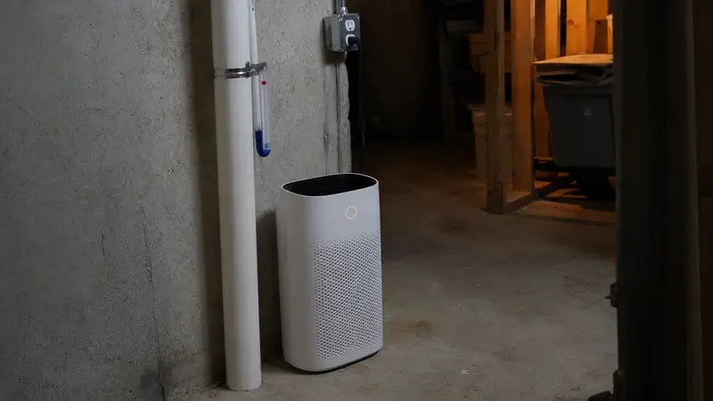Air purifier in a basement next to a radon pipe