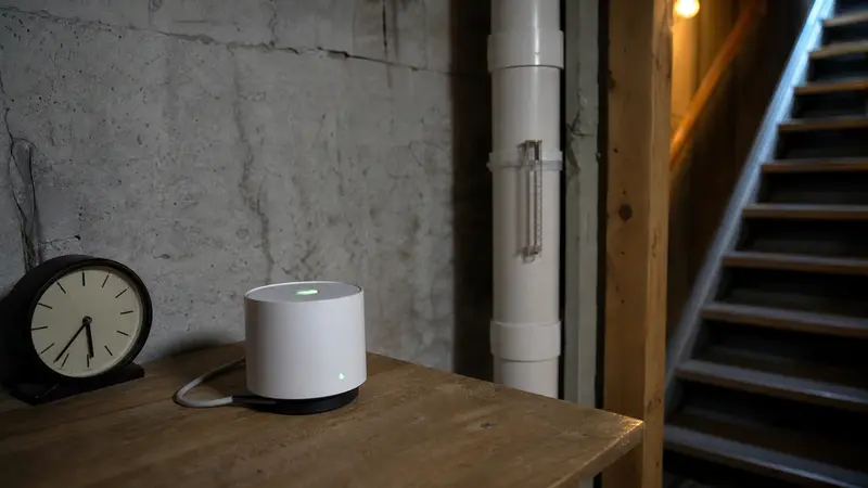 Radon monitor running on a basement table with a wall clock nearby