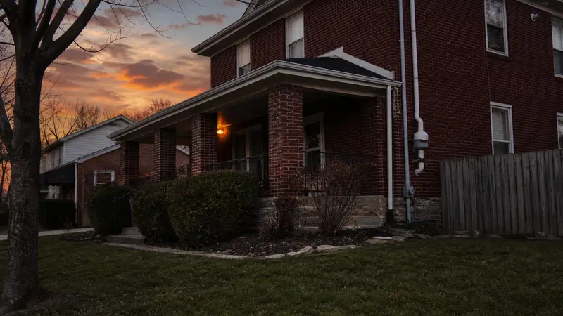 York brick home with a pending-sale sign in the yard at sunset